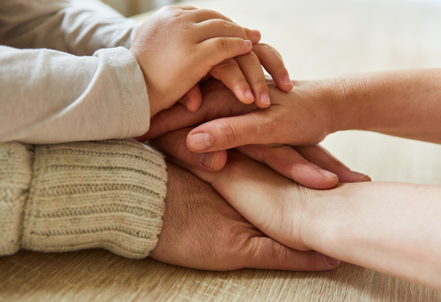 Stack of hands, from an older generation to the younger
