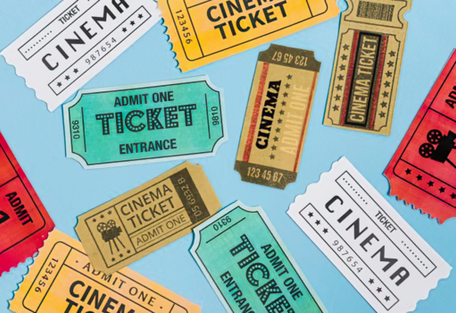 Paper movie tickets scattered on a blue background