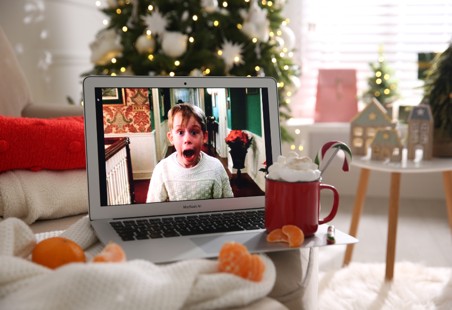 Home Alone playing on a laptop in front of a Christmas tree