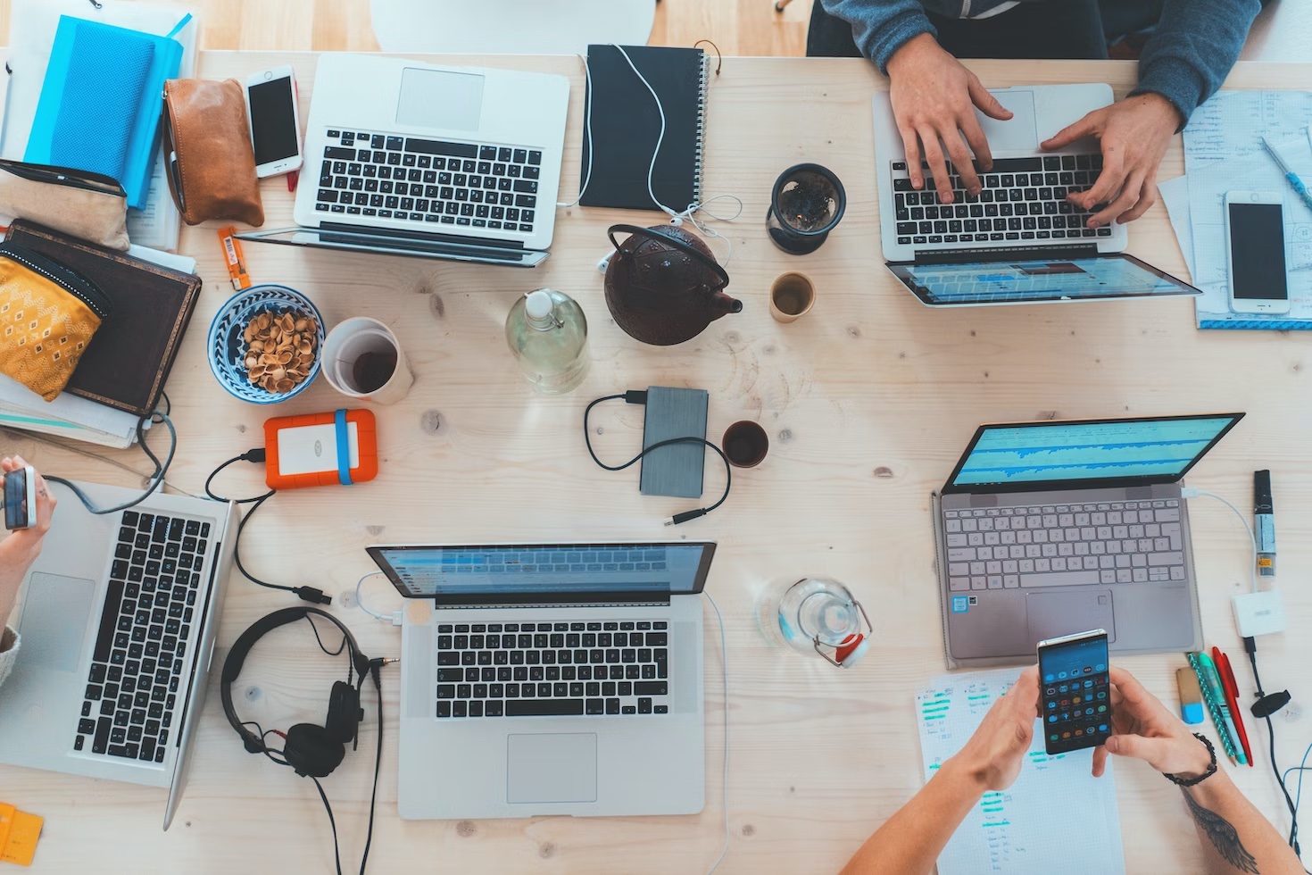 Four users on laptops working together.