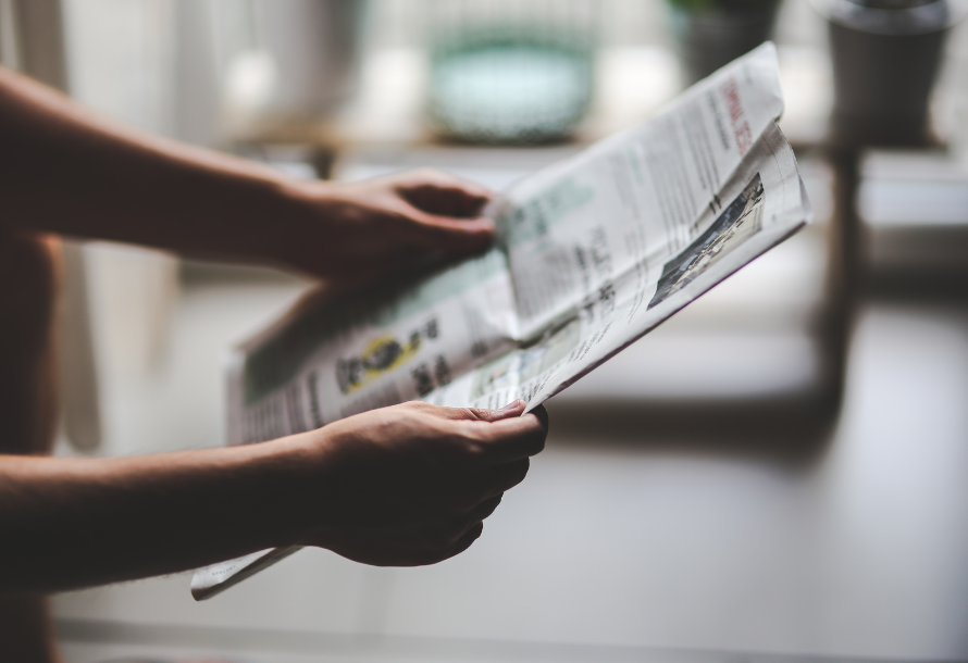Person holding an open newspaper